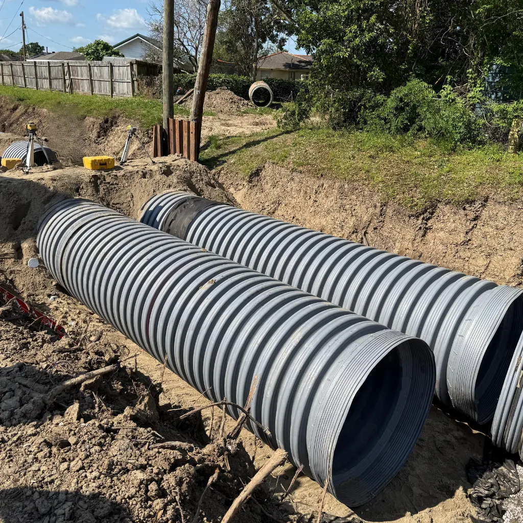 Corrugated polypropylene pipe Austin — TDR PRO 12–48 in pipe being lowered into the trench at Endeavor 290, Austin, Texas